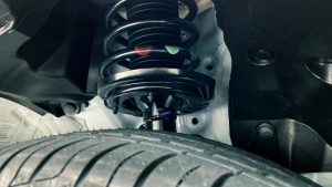 Close-up of a car coil spring and suspension assembly behind the tyre